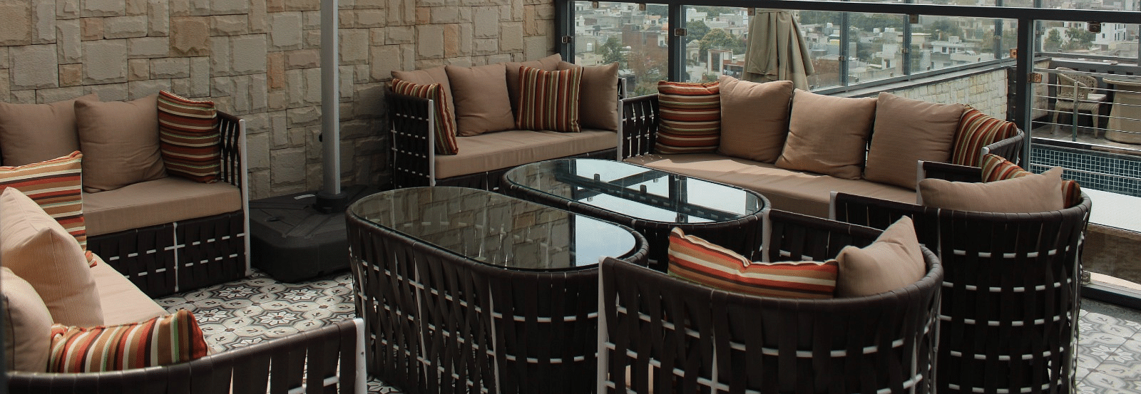 Rooftop lounge featuring sofas, pillows, and a patio offering stunning city views at BluSalzz Residence, Amritsar